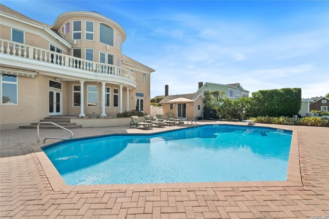 view of pool with a diving board, a patio, and french doors