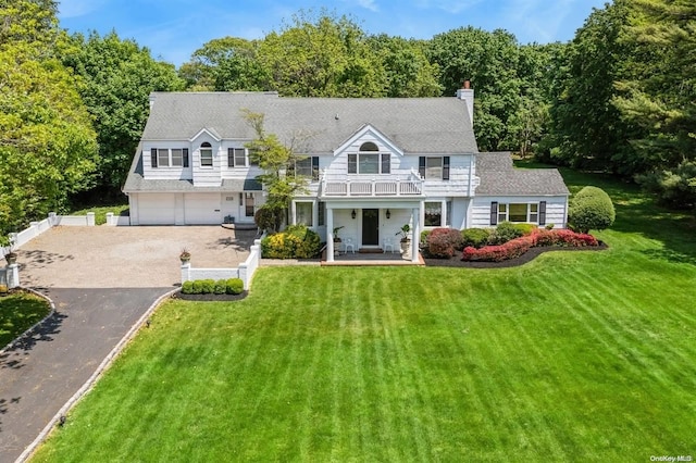1345 Harbor Rd, Hewlett Harbor, NY 11557 - view of front of home with a balcony, a front lawn, driveway, a garage, and a chimney