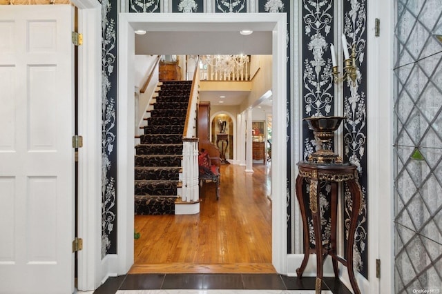 1345 Harbor Rd, Hewlett Harbor, NY 11557 - foyer entrance with stairs, arched walkways, wood finished floors, and wallpapered walls