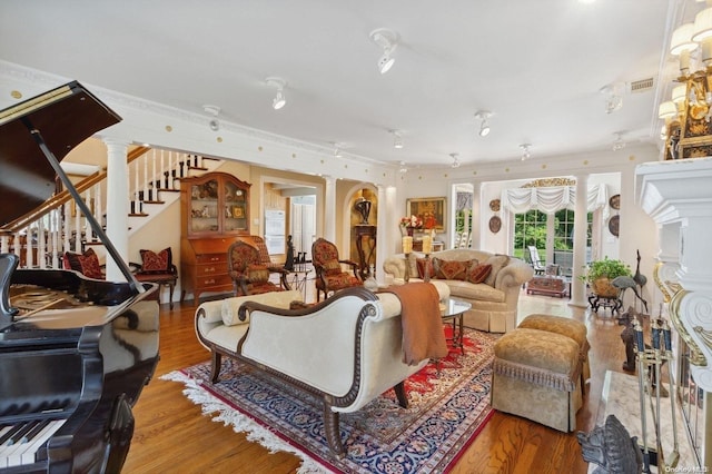 1345 Harbor Rd, Hewlett Harbor, NY 11557 - living room featuring decorative columns, wood finished floors, and stairs
