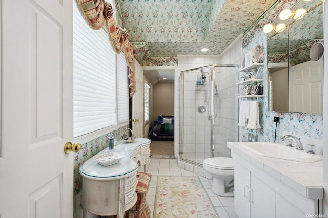 bathroom with tile patterned floors, a shower with door, vanity, and toilet