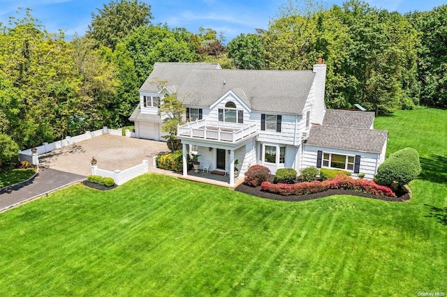 1345 Harbor Rd, Hewlett Harbor, NY 11557 - back of property with a yard, a balcony, driveway, an attached garage, and a chimney