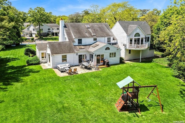 back of property featuring a playground, a patio area, and a lawn