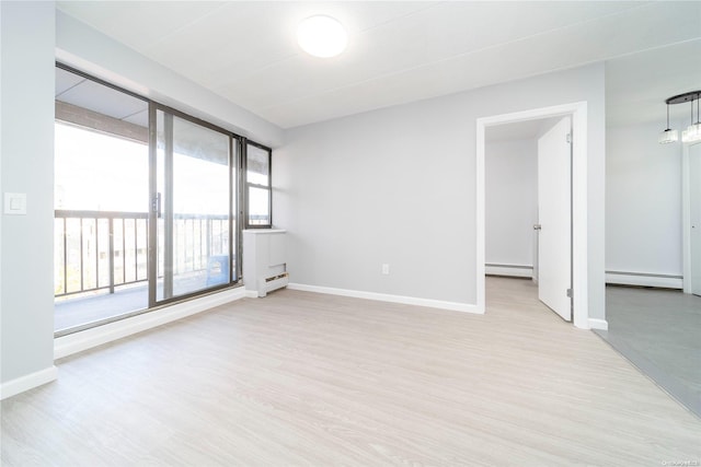 unfurnished room with light wood-type flooring and baseboard heating