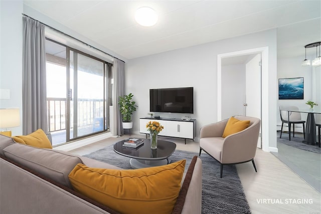 living room with light wood-type flooring, a baseboard radiator, and a wealth of natural light