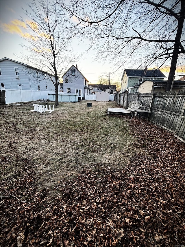 yard at dusk featuring a wooden deck