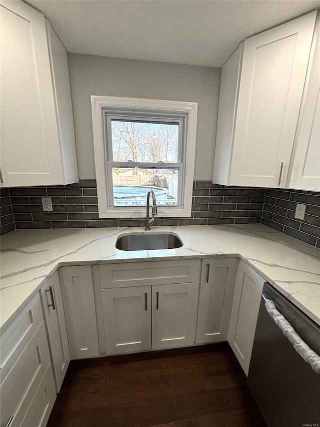 kitchen featuring stainless steel dishwasher, white cabinetry, and sink