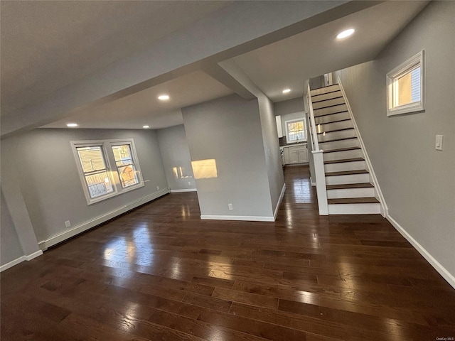 unfurnished living room featuring a baseboard radiator and dark hardwood / wood-style floors