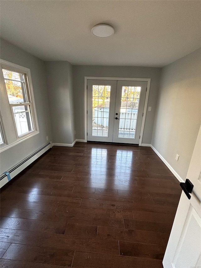 empty room with baseboard heating, french doors, dark hardwood / wood-style flooring, and plenty of natural light