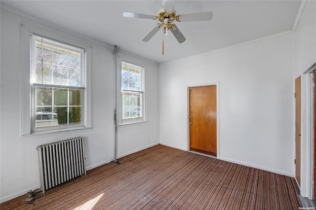 empty room with radiator heating unit, ceiling fan, and crown molding