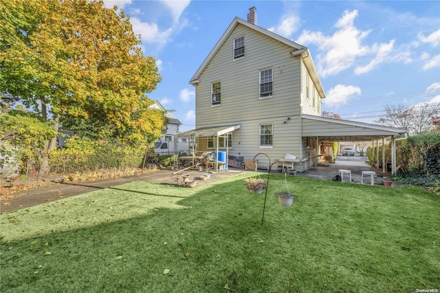 back of house featuring a carport and a yard