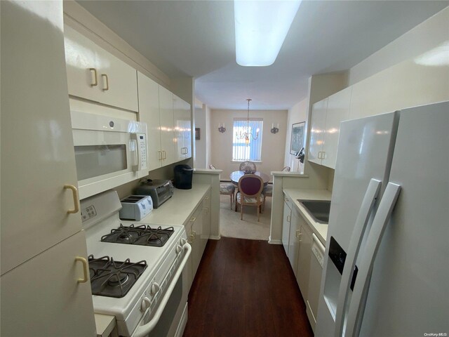5 Schenck Ave Unit 3E, Great Neck, NY 11021 - kitchen with white appliances, light countertops, a chandelier, white cabinetry, and dark wood-type flooring