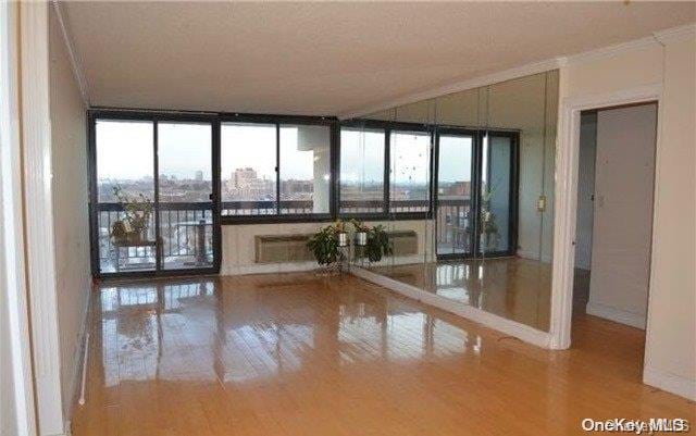 interior space with hardwood / wood-style floors, floor to ceiling windows, and ornamental molding