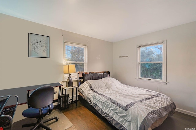 bedroom with dark wood-type flooring and a baseboard heating unit