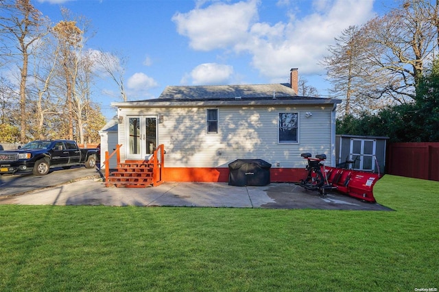 back of property with a patio area and a yard