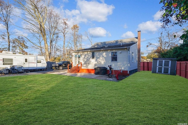 back of property featuring a yard, a shed, and a patio area