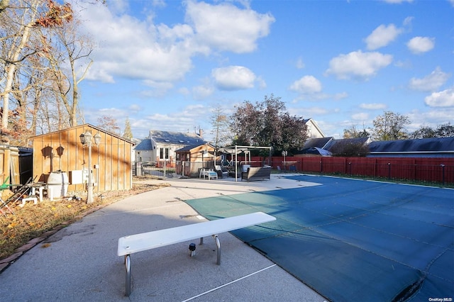 view of swimming pool featuring a patio area and a diving board