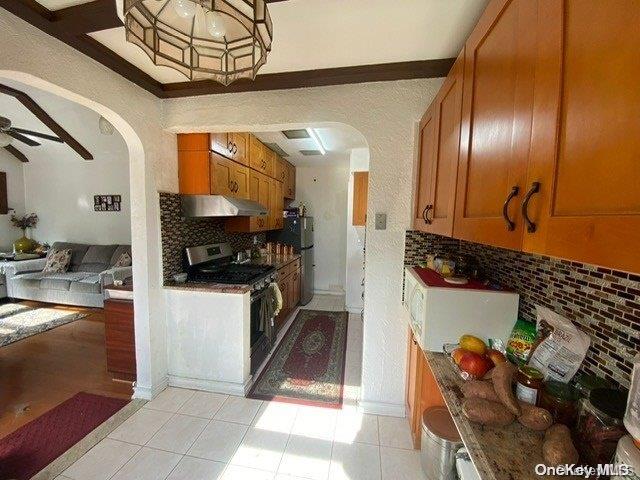 kitchen with light tile patterned flooring, tasteful backsplash, ceiling fan, electric range, and range hood