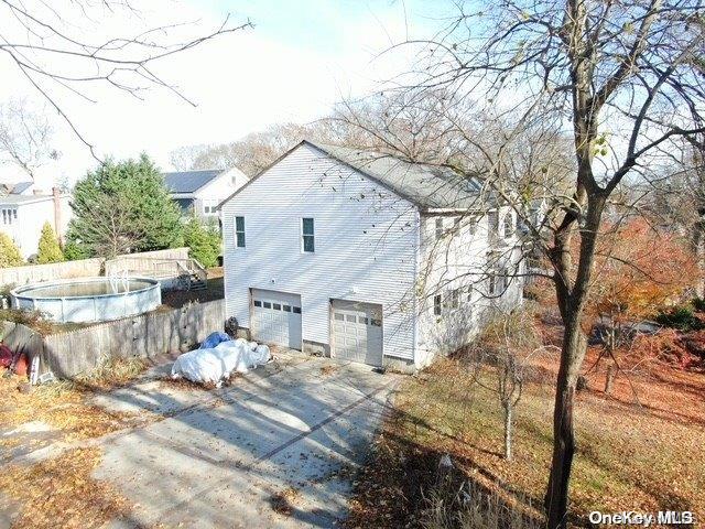 view of property exterior featuring a fenced in pool and a garage