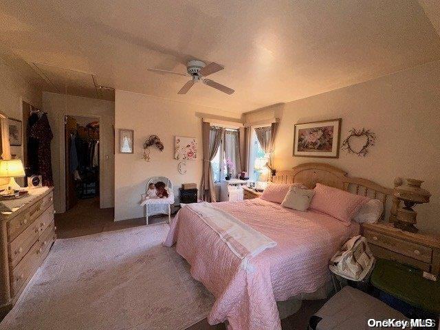 bedroom featuring a spacious closet, ceiling fan, light carpet, a textured ceiling, and a closet