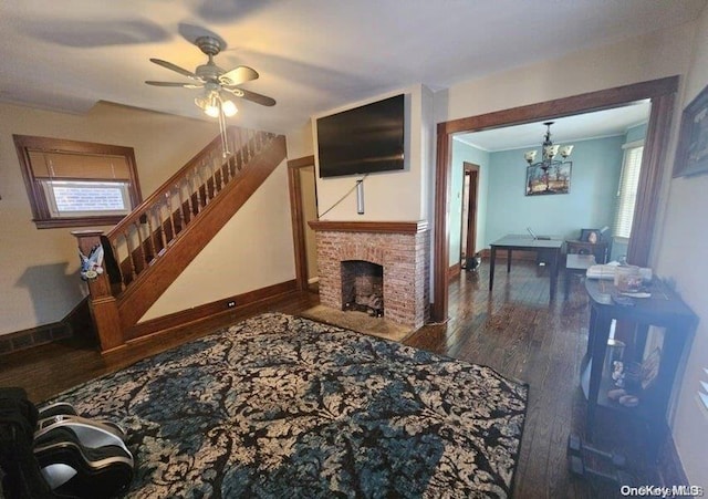 living room featuring a fireplace, hardwood / wood-style floors, ceiling fan with notable chandelier, and ornamental molding