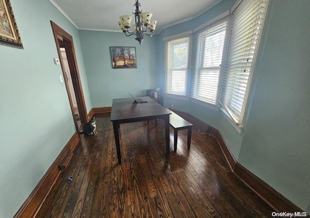 dining room with ornamental molding, dark wood-type flooring, and a chandelier