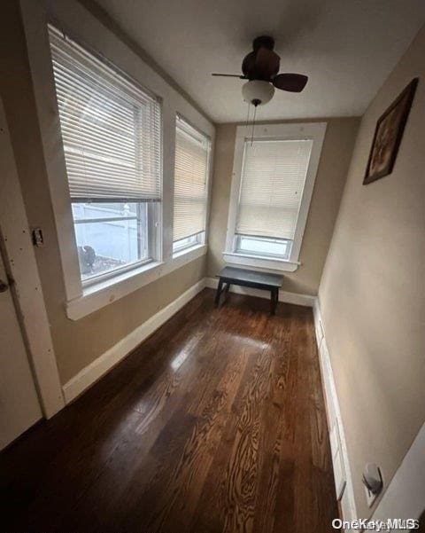 unfurnished dining area with ceiling fan and dark wood-type flooring