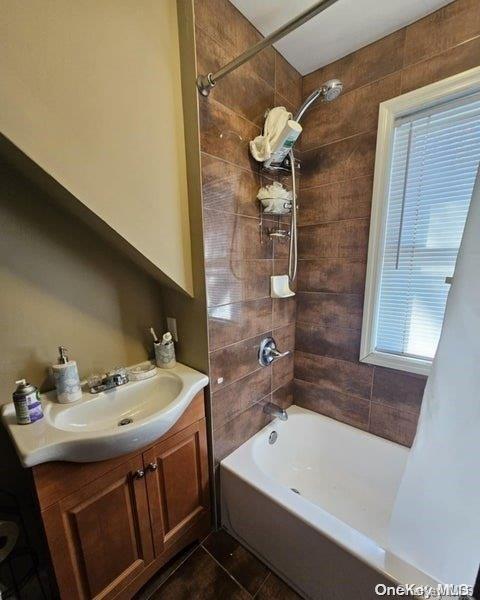 bathroom with vanity, tiled shower / bath combo, and tile patterned floors