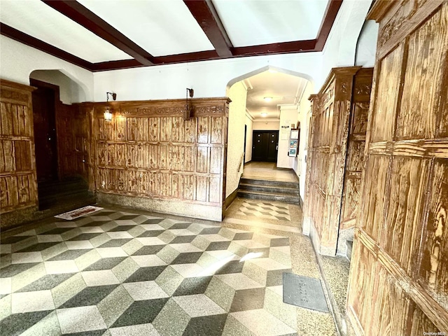 corridor featuring crown molding and wooden walls