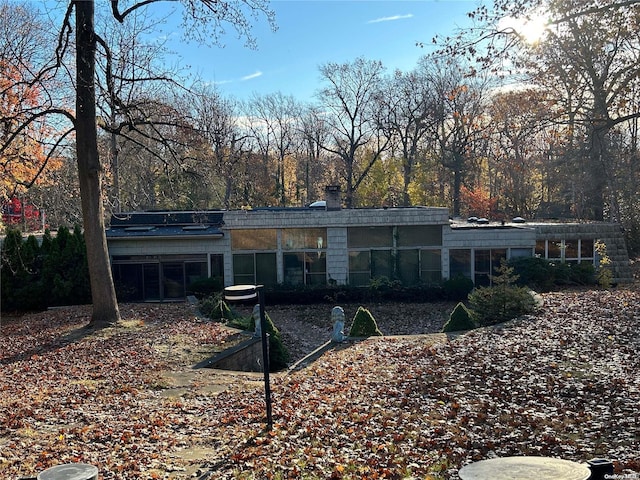 rear view of property featuring a sunroom