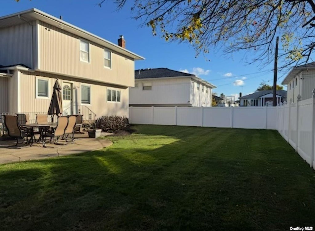 rear view of house with a yard and a patio