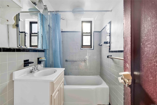 bathroom featuring shower / tub combo, decorative backsplash, vanity, and tile walls