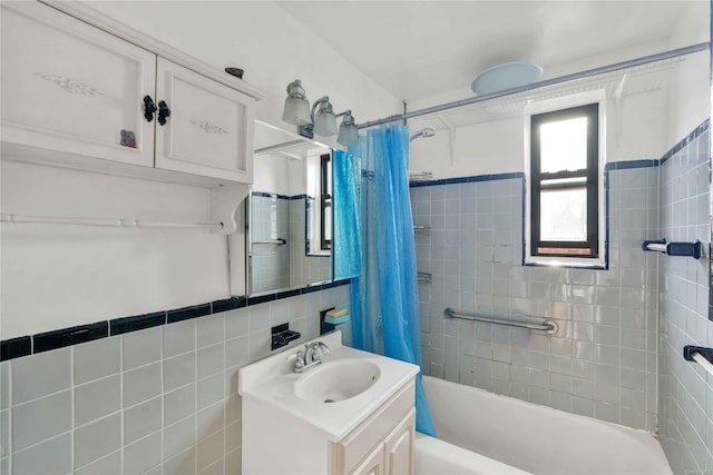 bathroom with shower / bath combo, tile walls, and vanity