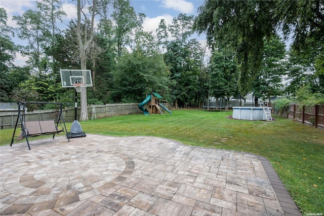 view of patio / terrace with a playground, a fenced in pool, and a trampoline