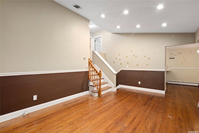 spare room with wood-type flooring and a baseboard heating unit