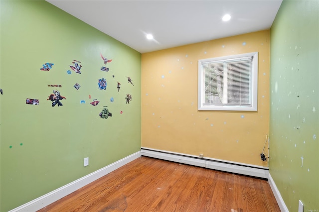 spare room with hardwood / wood-style floors and a baseboard radiator