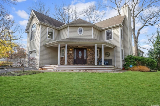 view of front of home with a garage, a front lawn, and a porch