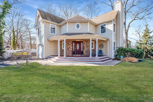 view of front of house featuring a porch, a garage, and a front yard