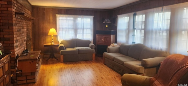 living room featuring ornamental molding, light wood-type flooring, and wooden walls