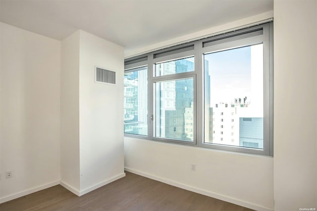 unfurnished room with dark wood-type flooring