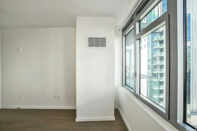 spare room with dark hardwood / wood-style floors and a healthy amount of sunlight