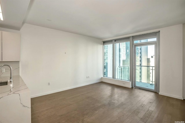 133-27 39th Ave Unit 9S, Flushing, NY 11354 - unfurnished living room featuring dark wood finished floors, a sink, and baseboards
