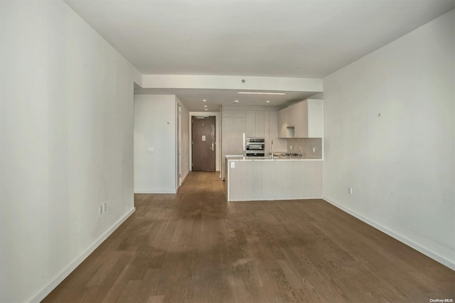 unfurnished living room with dark hardwood / wood-style floors and sink