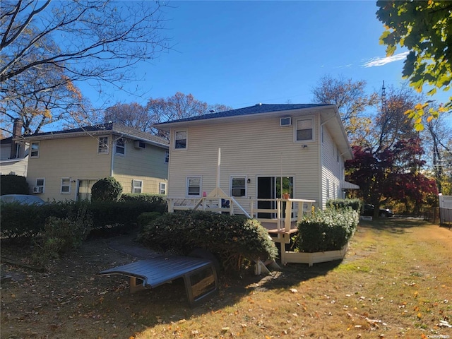 rear view of property featuring a lawn and a wooden deck