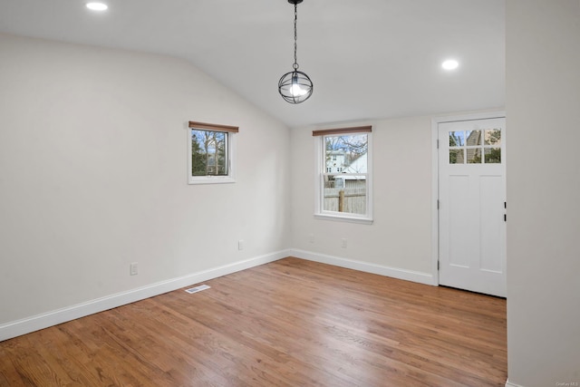 unfurnished dining area featuring baseboards, visible vents, light wood-style flooring, recessed lighting, and vaulted ceiling