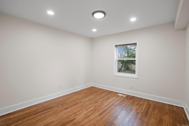 spare room featuring recessed lighting, baseboards, visible vents, and wood-type flooring