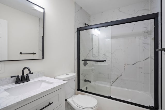 bathroom featuring enclosed tub / shower combo, toilet, and vanity