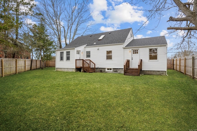 back of house with a shingled roof, a fenced backyard, a lawn, and entry steps