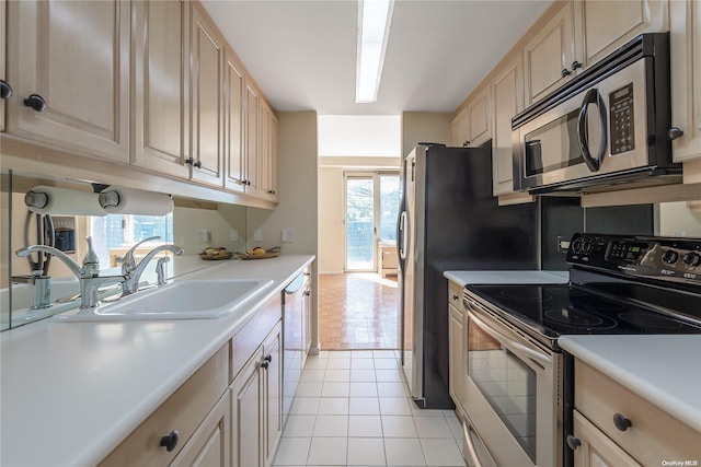 kitchen with light tile patterned flooring, appliances with stainless steel finishes, plenty of natural light, and sink