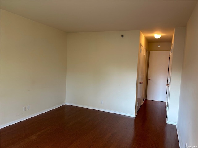 spare room with dark wood-type flooring